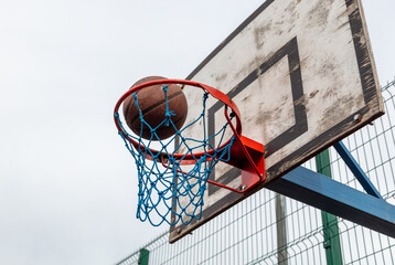 The basketball ball flies into the basket.