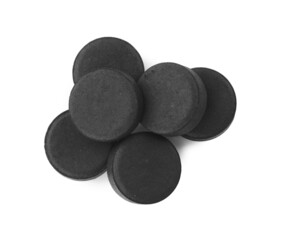Activated charcoal pills on white background, top view. Potent sorbent