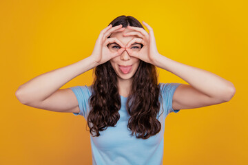 Close up photo of young cheerful girl happy positive smile show okay sign fooling tongue-out isolated yellow background