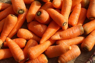 a collection of red carrots at a traditional market. fresh vegetables ready to be sold for consumption.