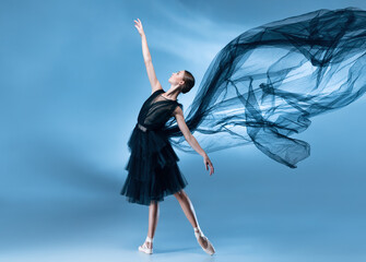 Young and graceful ballet dancer in black stage outfit, dress isolated on white blue studio background in neon light.