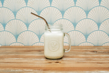 Delicious guava smoothie in glass cup with metal straw on wooden table
