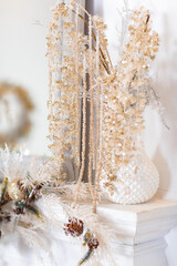 Christmas interior decoration. Glass beads decoration on white fireplace.