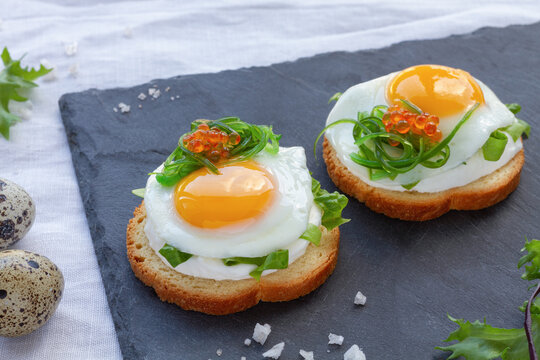Delicious toasts with fried quail eggs