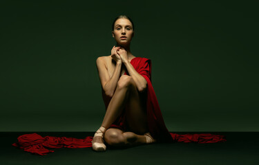 Graceful classic ballerina posing like greek goddess isolated on dark studio background. Grace, art, performance concept.