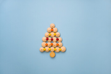 Christmas tree made of cookies and sweets on a blue background with space for text. Christmas baking concept.