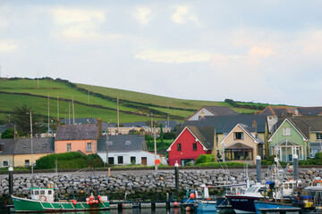 Fototapeta na wymiar Various colorful houses and boats lining DIngle Bay in Dingle, Ireland. 