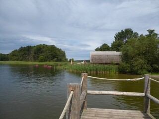 Fototapeta premium Thatched boathouses in Mirow Lake near Granzow, Mecklenburg-Western Pomerania, Germany