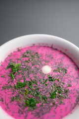 Obraz na płótnie Canvas cold beetroot soup with cucumber, boiled egg, dill and yogurt in white bowl