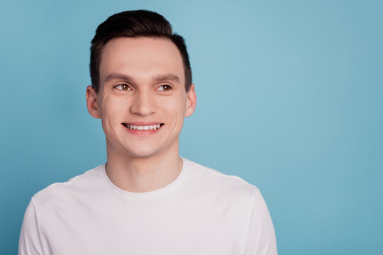 Photo of cheerful young man beaming smile wondered look empty space isolated on pastel blue color background
