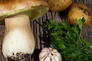 Various ingredients for cooking wild porcini mushrooms: porcini mushroom, potatoes, onion, garlic
