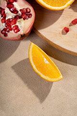 A slice of orange on a sandy beige background. View from above