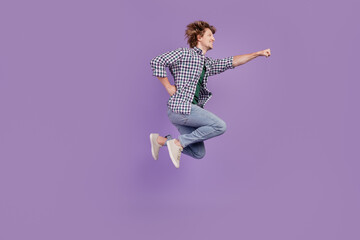 Full body profile side photo of young cheerful man air jump look empty space superhero isolated over violet color background