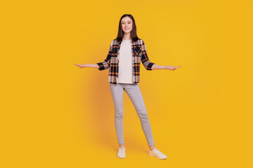 Photo of positive promoter lady hands demonstrate empty space compare options isolated on yellow color background