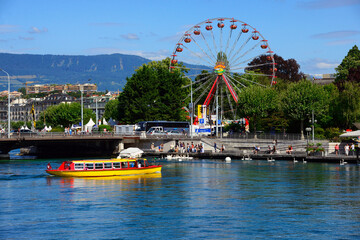 City of Geneva, yellow tram - public boat connecting shores of Rhone river and Geneva Lake, Mont...