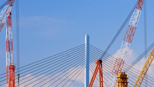Large cranes moving over the bridge, construction scene