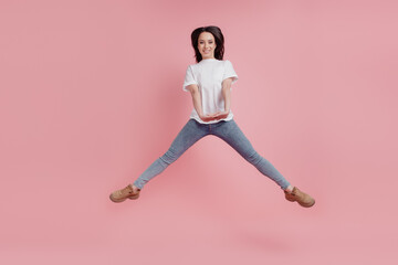 Fototapeta na wymiar Full length photo of young excited girl jump up active casual outfit carefree isolated over pink color background