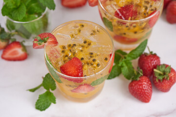 the passion fruit cocktail with mint and ice cubes in glass, homemade fresh fruit, passion and strawberry  sweet fruit drinks, fruit drink for healthy concept, selective focus.