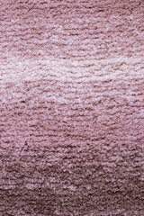 Red brown fabric texture. Close-up of a pink fluffy soft bath mat or rug or textile background. Macro photograph. Beautiful bright backdrop.