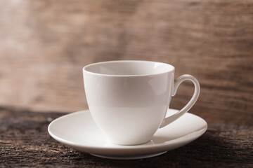 white small ceramic espresso coffee or tea cup on wood background vintage tone