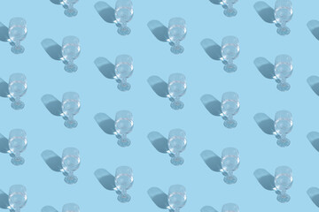 Fototapeta na wymiar Glass with water and shadow pattern on blue background