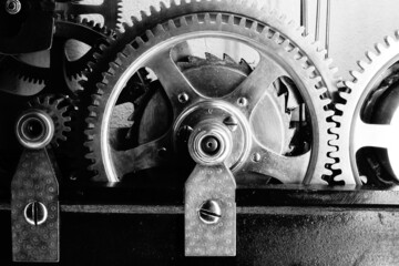 Engranaje de un reloj industrial retro con sus ruedas dentadas, en blanco y negro