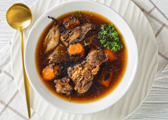 beef broth of beef meat on bones with veggies