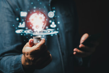 Businessman holding light bulb and mobile smartphone having new ideas of business with innovative technology network connection. Innovation concept. copy space for text.