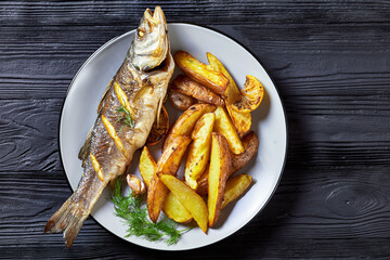 Whole roasted sea bass and potato, copy space