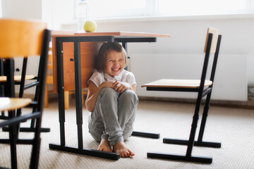 healthy snack at school, green apples and water at school recess. A girl sits under desk in...