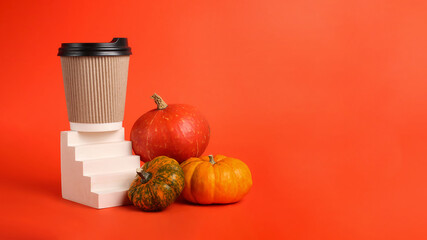 Assortment from pumpkins near geometrical podium with craft coffee cup.Concept of the spicy pumpkin...