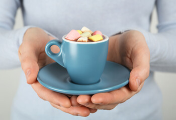 Fototapeta na wymiar Woman holding cup of delicious hot chocolate with marshmallows, closeup