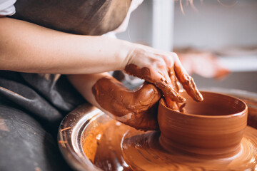 Female hands close up shaping clay pot