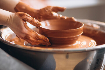Female hands close up shaping clay pot