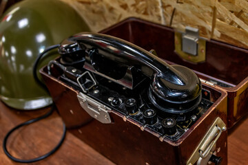Old military telephone next to the helmet