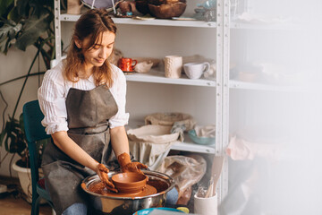 Young woman at her studio on a pottery workshop