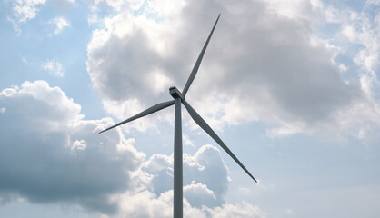 Fototapeta premium View of a windmill or Wind turbine against a blue sky. Renewable energy source. Electricity production . 