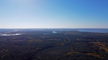 Panoramic aerial view of forest landscape with blue sky.