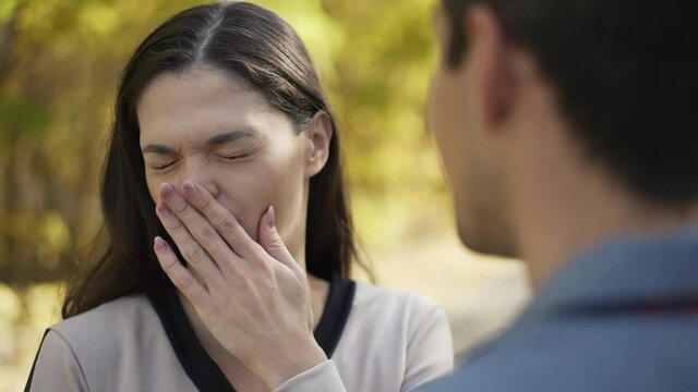 Bad breath. Woman covers her nose and turns away
