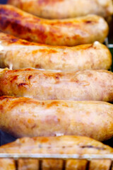 Delicious sausage close-up vertical photo on the background of the grill. Selective focus