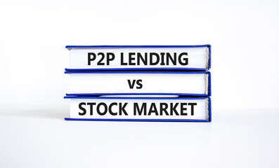 P2P, peer to peer lending vs stock market symbol. Concept words 'P2P lending vs stock market' on books. Beautiful white background, copy space. Business and P2P lending vs stock market concept.