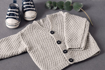 small knitted warm clothes for the baby, natural materials and colors, preparation for the birth of a child,