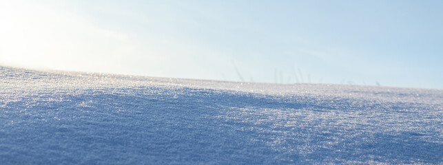 Snowy background, snowy surface with a clearly expressed texture of snow in the morning sun