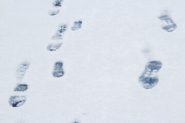 Footprints of a man on white snow in winter, winter background