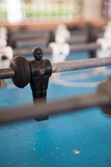 Foosball game, also known as Totó. Black and white players on the blue field. Selective focus. Shallow depth of field