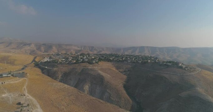 Jewish settlement at the desert of Judea and Samaria in Israel . Aerial view drone shot of village Houses on top hill mountains view. Outdoor Mediterranean coexist living