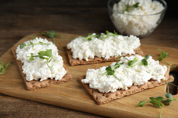 Crispy crackers with cottage cheese and microgreens on wooden table, closeup - obrazy, fototapety, plakaty