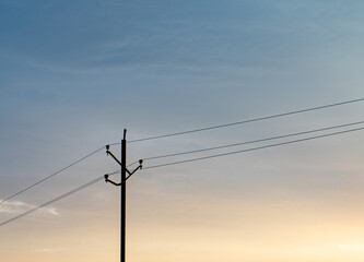 Electricity pole over blue and orange sky minimal photo.