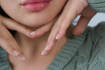 Obraz na płótnie Canvas Hands with manicure and lips of a girl