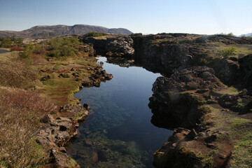 krystalicznie czysta woda pośród skał islandia thingvellir - obrazy, fototapety, plakaty